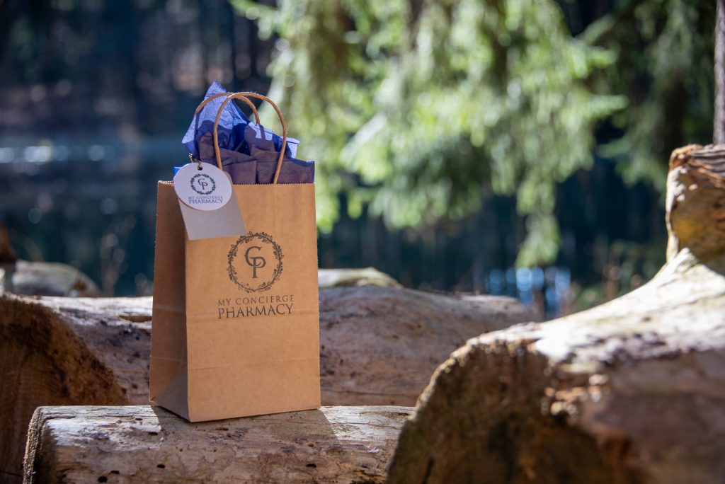 My Concierge Pharmacy delivery bag outdoors on a wooden surface, representing personalized pharmacy delivery and attentive local care.